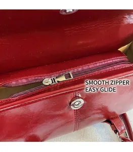 Detailed close-up of dark red leather bag interior with smooth metal zipper and magnetic buckle