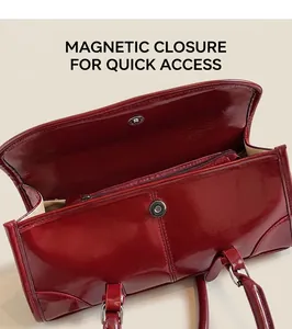 Detail view of the secure magnetic closure and internal zipper pocket of the red handbag
