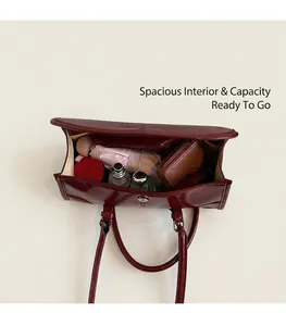 Top view of spacious burgundy leather bag interior with umbrella and daily essentials