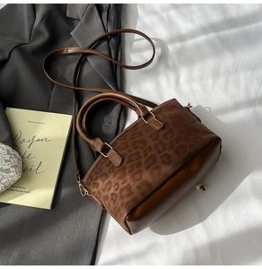 Detail showing vintage leopard print bucket bag with dual handles and suede texture