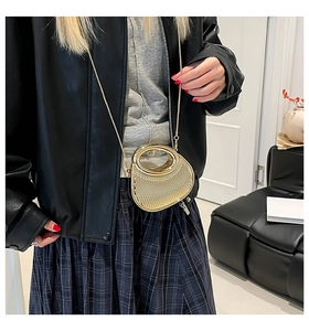 Close-up of golden mini crossbody bag featuring a pleated texture and chain strap