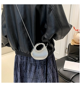 Silver metallic evening bag with circular handle and chain strap shown on model