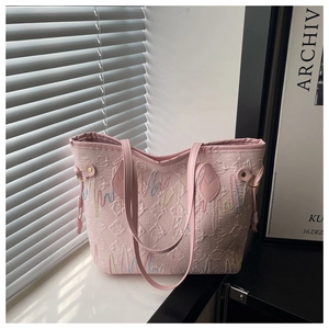 Detail of pink embroidered tote bag with textured lettering and wavy line stitching