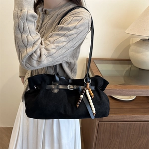 Retro black suede tote bag with wooden bead charm and silver buckle detail on shoulder strap