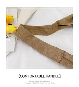 Détail de la poignée du cabas en daim marron clair avec coutures doubles de haute qualité