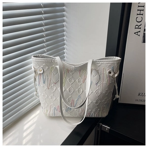 Detail of white tote bag with colorful wave embroidery and textured fabric finish