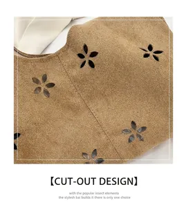 Gros plan d'un sac à bandoulière en daim marron avec des motifs floraux découpés au laser
