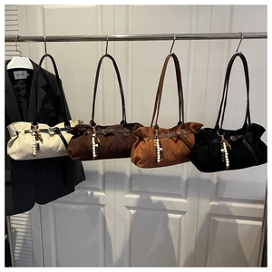 Detail van vier suède shopper tassen in wit, bruin, tan en zwart met kralenhanger