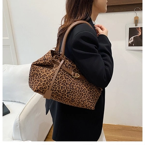Leopard print tote bag detail showing the brown leather handle and soft fabric texture