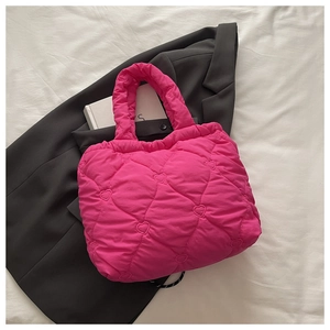 Detail of hot pink quilted tote bag with heart patterns and soft padded texture