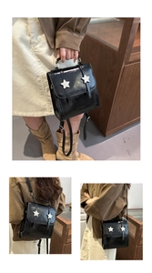 Close-up of black glossy mini backpack with white star patterns and dual buckle straps