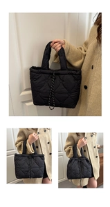 Detail of black quilted tote bag with heart patterns and drawstring closure design