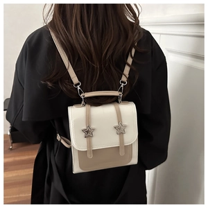 Détail d'un sac à dos minimaliste crème et kaki avec des boucles en forme d'étoile
