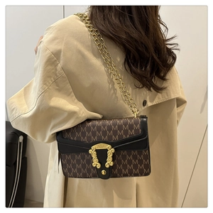 Retro monogram shoulder bag with gold relief buckle and chain strap on female model