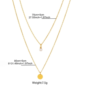 Detail view of double-layer necklace specs featuring white pearl and gold disc pendants