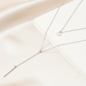 Double-layered stainless steel necklace featuring a vertical bar and round coin pendant