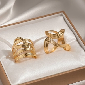Macro shot of 18k gold plated threaded wave rings displayed on silk in a gift box