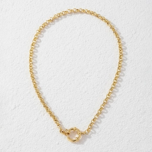 Detail of a golden Rolo chain necklace featuring a polished round mariner spring clasp