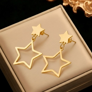 Minimalist gold stainless steel star drop earrings displayed in a luxury jewelry box