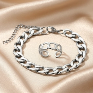 Polished silver stainless steel Cuban link bracelet and ring set on champagne satin
