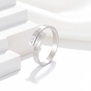 Detail of silver I am enough engraved stainless steel adjustable ring on silk background
