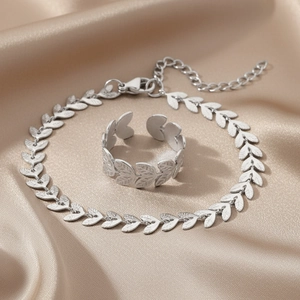 Ensemble collier et bague feuilles argentées sur un tissu en soie champagne élégant