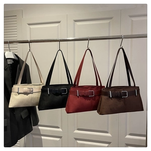Row of suede underarm bags in beige, black, burgundy, and brown with retro buckle detail