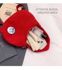 Interior view of red corduroy crossbody bag showing capacity for phone and cosmetics