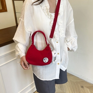 Red corduroy crescent shoulder bag with cartoon patch and plush white doll charm