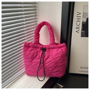Detail of pink dumpling bag featuring heart-shaped quilting and black drawstring closure