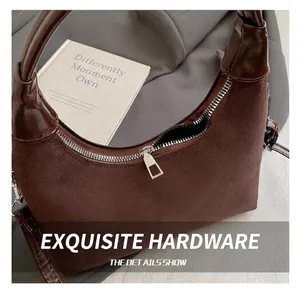 Detailed macro view of dark brown suede hobo bag showing silver zipper and leather strap