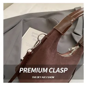 Detail of high-quality silver metal hook and dark brown suede material on the handbag