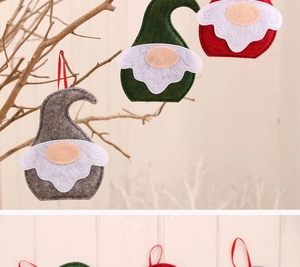 Gros plan de trois gnomes de Noël en feutre faits à la main suspendus à une branche