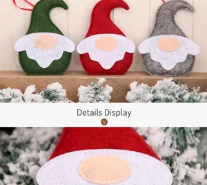 Gros plan détaillé de gnomes de Noël artisanaux en feutre avec couture et branche de cèdre