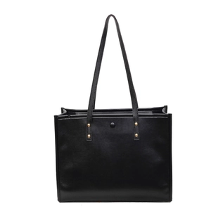 Minimalist black PU leather tote bag with gold stud accents on slim shoulder straps