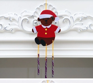 Detail of Christmas teddy bear wind chime made of red felt with three metallic tubes