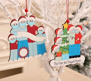 Detail of wooden Christmas ornaments featuring masked family and 'The Year We Stayed Home' text