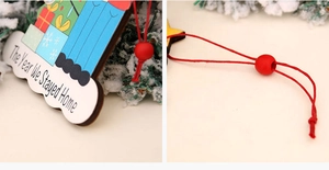 Detail of wooden Christmas ornament with The Year We Stayed Home text and red cord