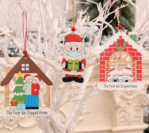 Dettaglio di ornamenti natalizi in legno con Babbo Natale mascherato su albero