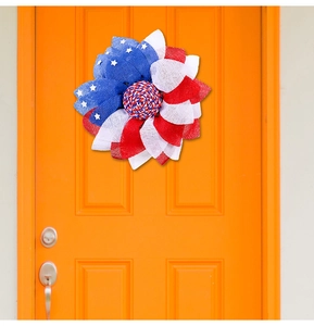 Detail of USA Independence Day floral wreath in red, white, and blue mesh on an orange door