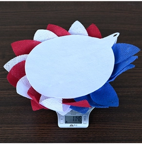 Detailed view of patriotic flower wreath showing 114.8g weight on digital scale