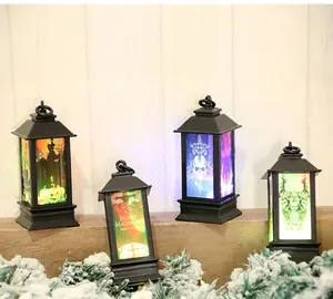 Détail de quatre lanternes LED d'Halloween avec motifs citrouille et fantôme sur bois