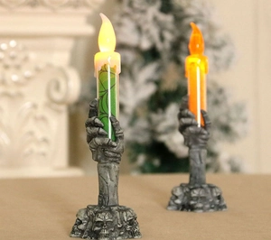 Detail of Halloween ghost hand LED candles with skull base and spider web patterns