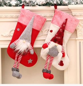 Detailed close-up of plush Christmas gnome stockings hanging by a warm fireplace