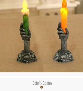 Detail showing two LED skeleton hand candles with spider web glitter and skull bases