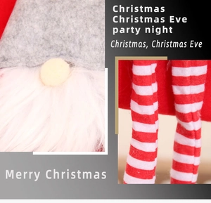 Detail of plush Christmas gnome stocking with felt hat and striped legs for holiday decor
