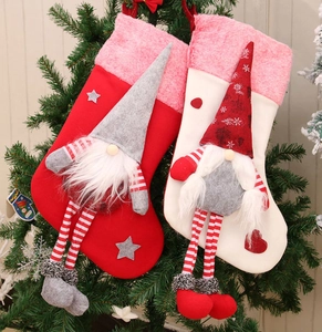 Close-up of plush Christmas stockings with long-legged gnomes on a decorated tree