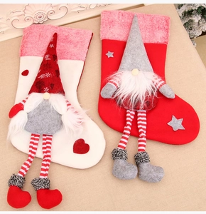 Detail of Christmas stockings featuring long-legged gnomes with plush hearts and stars