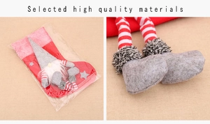 Detail of plush Christmas gnome stocking with red white striped legs and star embroidery