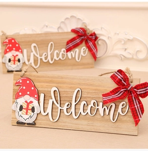 Close-up of wooden Welcome sign with Christmas gnome and red plaid fabric bow